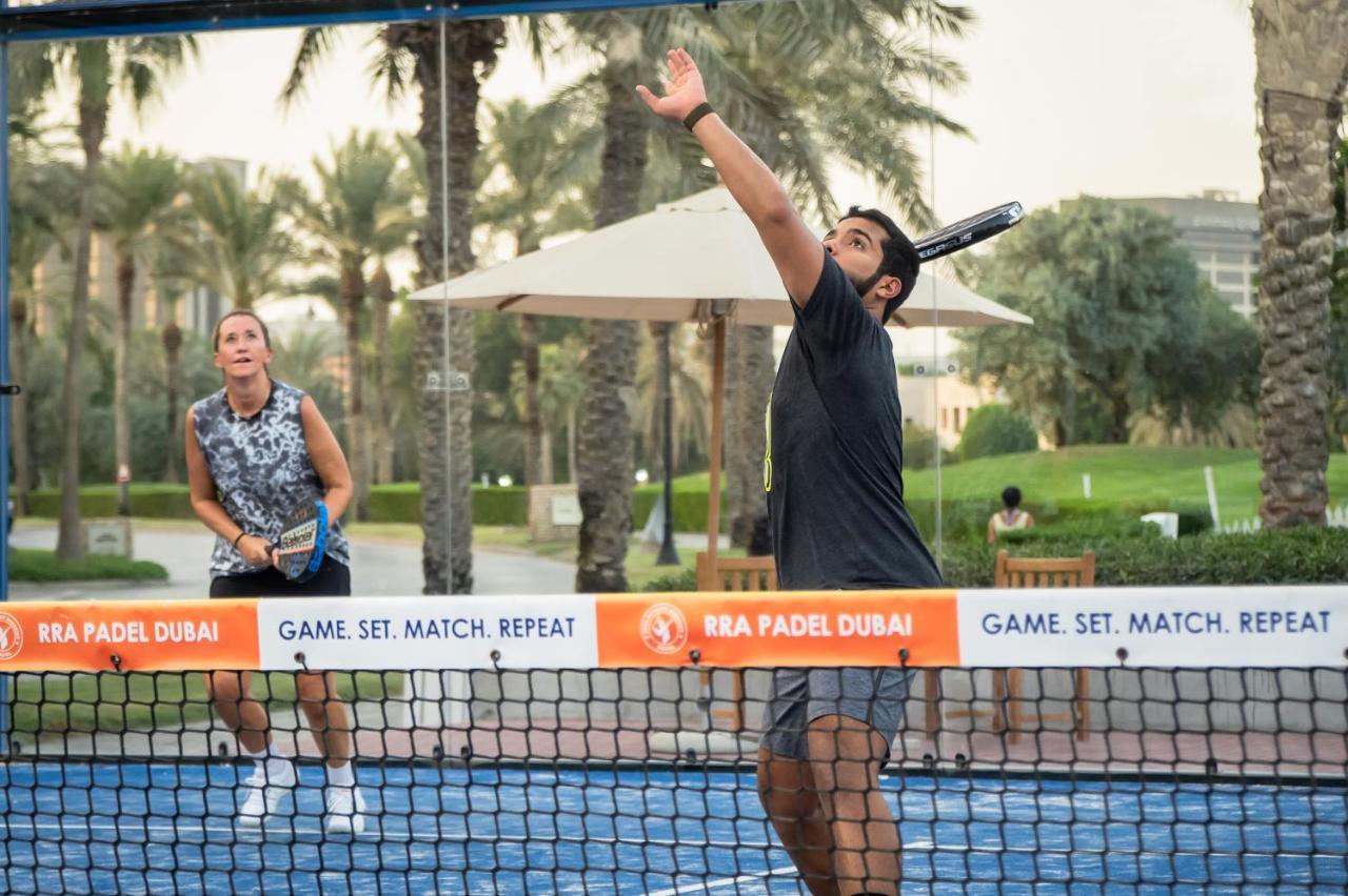 Hotel Park Hyatt Dubai Esterno foto A player serves in a paddle tennis match